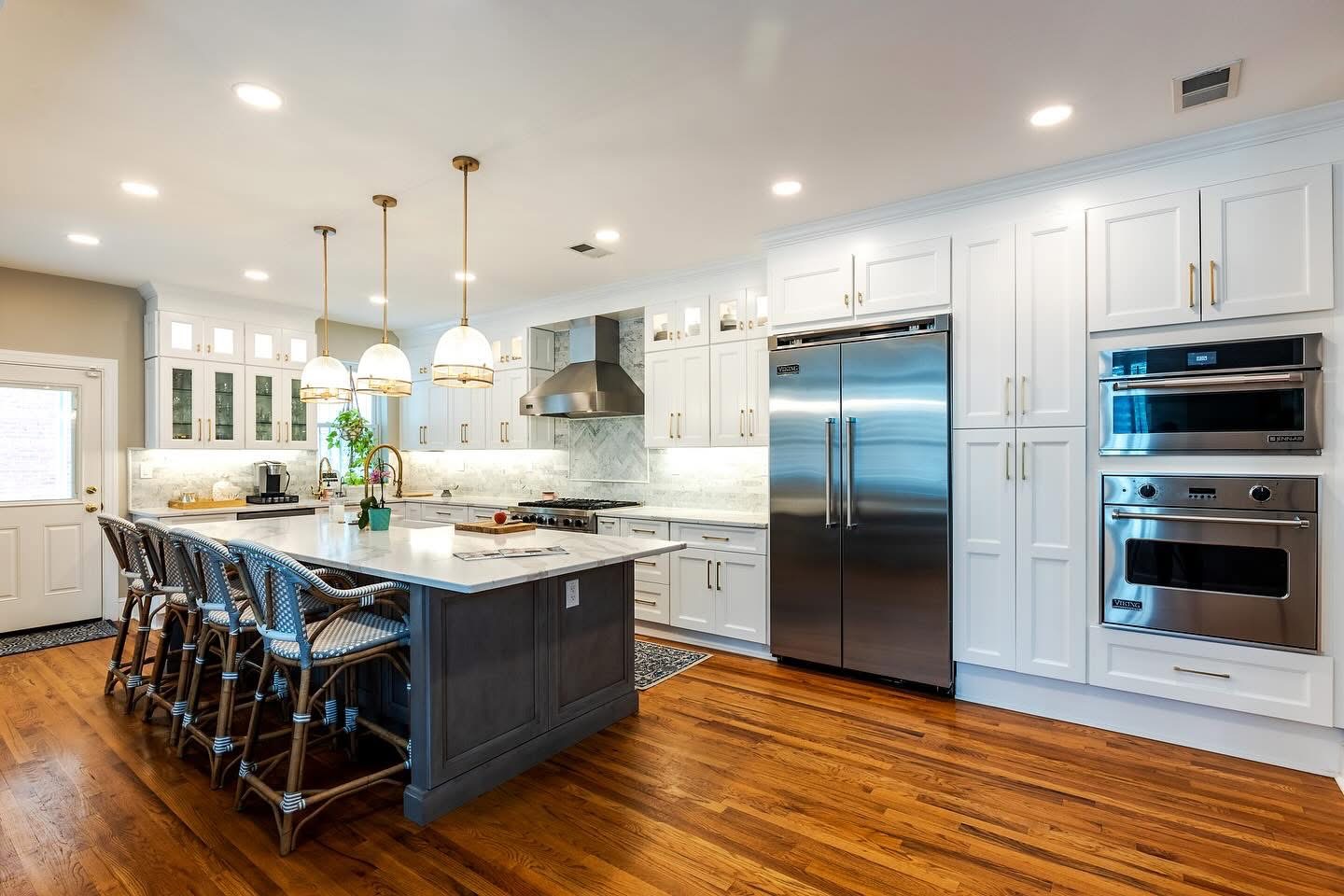 After: Wide view of wide-plank hardwood floors and modern white kitchen layout in Plano