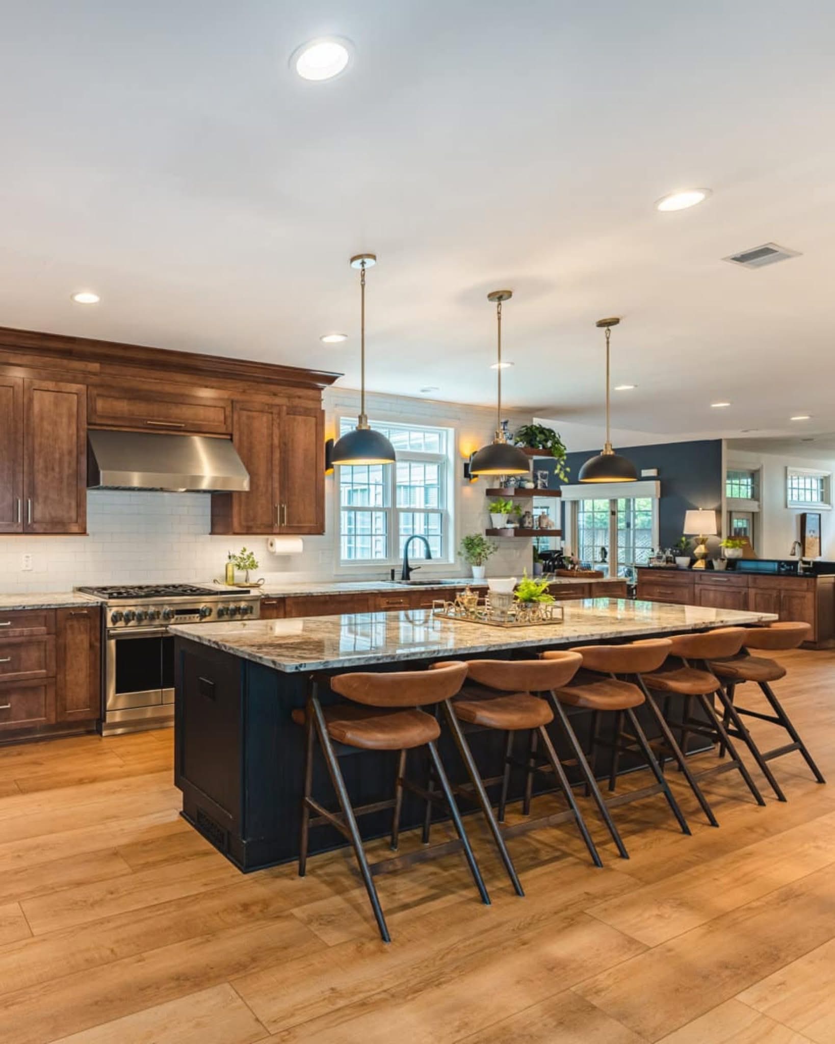 Before: Wide view of wide-plank hardwood floors and modern white kitchen layout in Plano